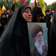 Demonstranter i Teheran håller upp porträtt på Irans högsta ledare Ali Khamenei. Bild från 31 juli. 