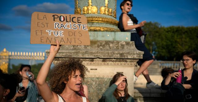 Demonstration i Paris. En kvinna håller upp en skylt med budskapet ”polisen är rasister och dödar barn.” Lewis Joly / AP
