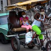 En man kör cykeltaxi i Havanna.