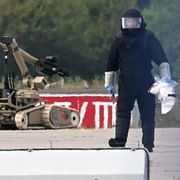 En kriminaltekniker arbetar intill en bombrobot vid ett ukrainskt flygplan på Leipzig/Halle-flygplatsen i Tyskland den 5 augusti. En drönare med sprängladdning hade hittats i närheten.