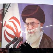 Folk håller upp en bild på ayatollan efter hans död.