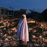 En kvinna står i ruinerna efter en marknad som förstörts i jordbävningen i Indonesien, 8 december, 2016.