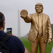 USA:s president Donald Trump med en bitcoin-symbol i handen.