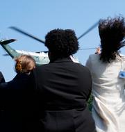 Åskådare ser på medan president Biden lyfter i Marine One.  Susan Walsh / AP