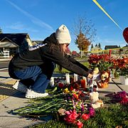 Människor lägger blommor utanför skolan, 16 oktober.