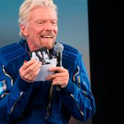 Richard Branson holds up a photograph of his parents during a news conference after he and five crewmates from his Virgin Galactic space-tourism company reached the edge of space following a launch near Truth or Consequences, N.M., on Sunday, July 11, 2021. Branson said he also carried photos of his children and others during the flight.