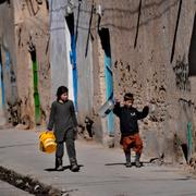 Barn med vattenbehållare i Kabul.