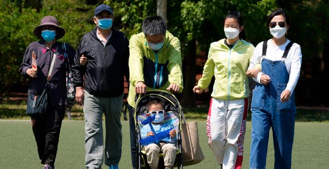Familj på parkpromenad i Peking.  Ng Han Guan / AP