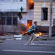 En man springer framför ett sjukhus som träffats av en rysk drönarattack i centrala Kyjiv.