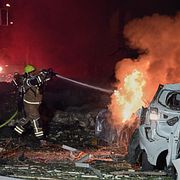 Brandman släcker en brand efter iransk roboattack i Tel Aviv på lördagen.