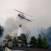 En helikopter vattenbombar branden i Drammen.