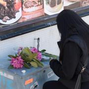  En kvinna lämnar blommor vid mordplatsen kort efter dådet förra året. 