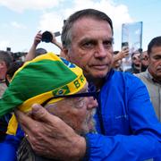 Brasiliens ex-president Jair Bolsonaro kramar om en anhängare. Trump har krävt att Brasilien ska lägga ner en rättsprocess mot Bolsonaro, som anklagas för kuppförsök.