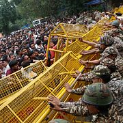 Demonstranter försöker forcera en av polisens barrikader under en protestmarsch i New Delhi på måndagen.
