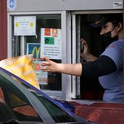 En anställd serverar hamburgare på ett McDonalds i Los Angeles. Anställda inom snabbmatsbranschen arbetar ofta för låga minimilöner i USA. I Kalifornien höjdes den förra året till 20 dollar i timmen.