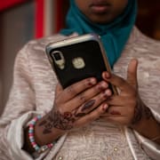 Flicka med mobiltelefon i Rumänien, arkivbild. 