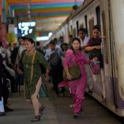 Women rush out of a train during peak hours at Churchgate station in Mumbai, India, 2023.