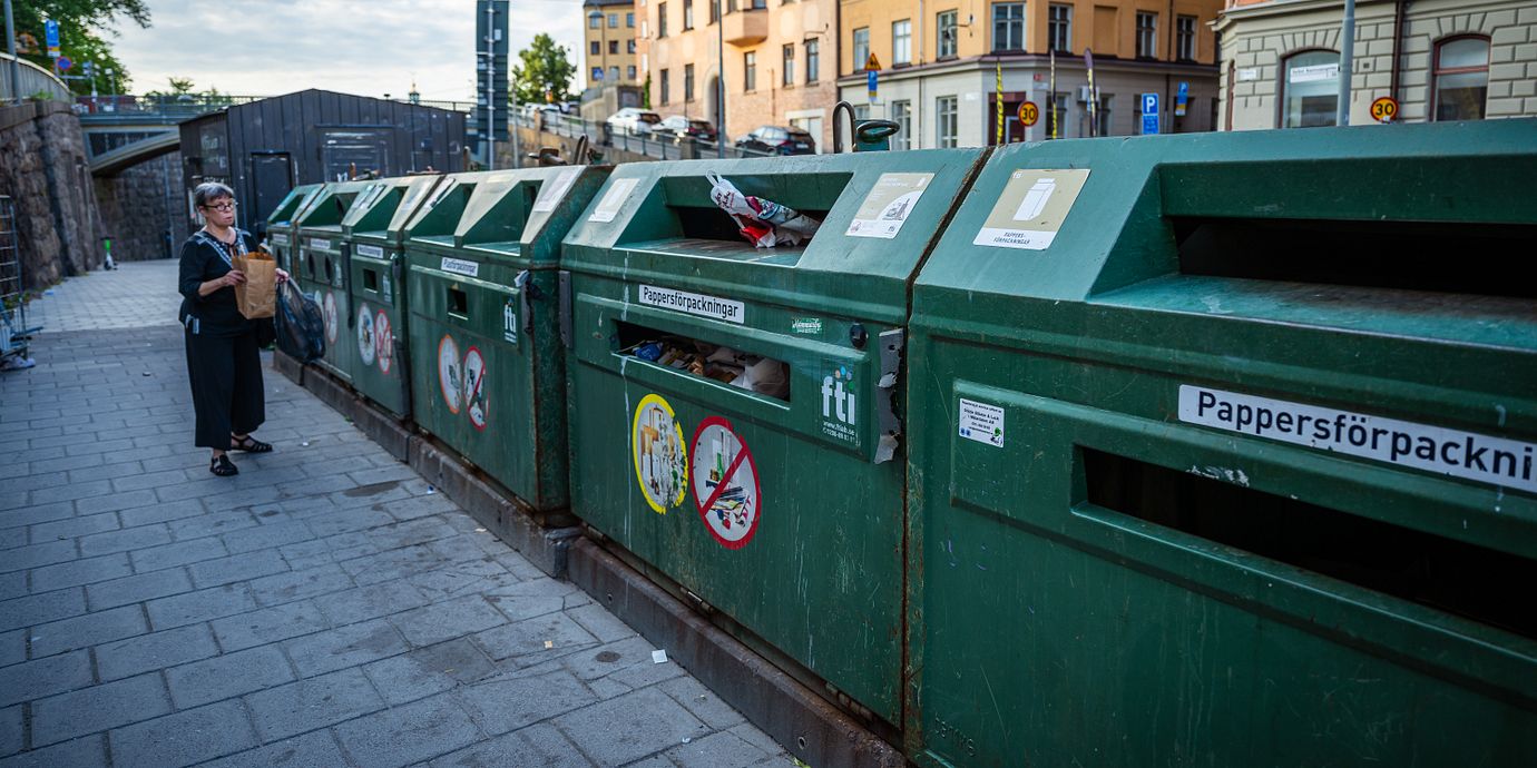 Arkivbild: En kvinna slänger i återvinningen.