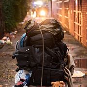 En migrant flyttar sina tillhörigheter efter att ha avvisats av polis från den övergivna skolbyggnad i Barcelona där han bott. Bild från december 2025.