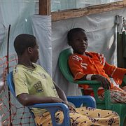 Två flickor sitter utanför ett isoleringscentrum i Bunia, Kongo-Kinshasa.