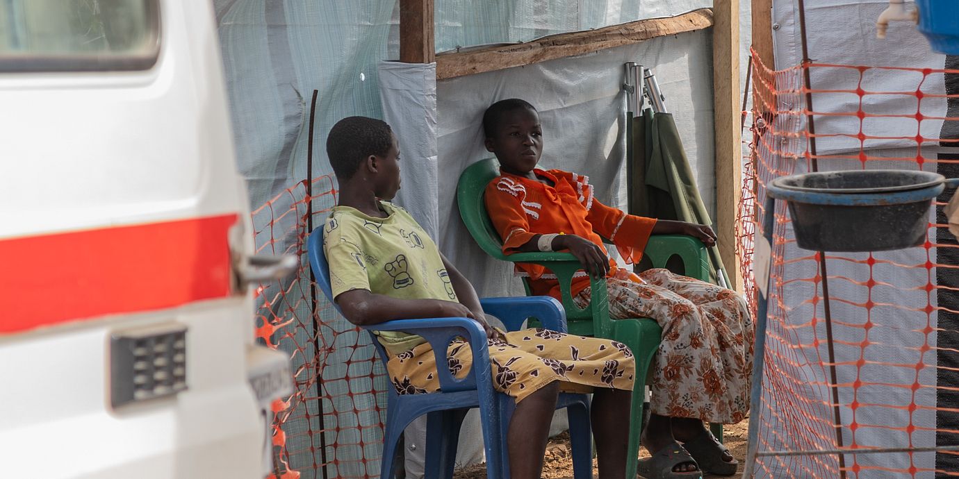 Två flickor sitter utanför ett isoleringscentrum i Bunia, Kongo-Kinshasa.