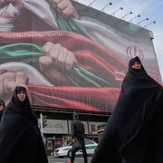 Kvinnor gör segertecknet när de passerar under en skylt med patriotiskt budskap i Teheran i förra veckan. 