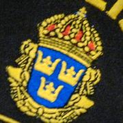 Ett polismärke på en uniform. Genrebild. 