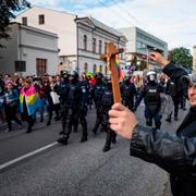 Motdemonstranter håller upp kors när pridetåget passerar.