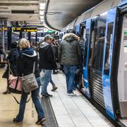 Resenärer kliver på och av ett tunnelbanetåg vid Slussen i Stockholm. 
