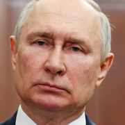 En förstörd byggnad i Cherson och en bild på Putin. 