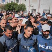 Sörjande vid journalisten Hassan Eslaiahs begravning. Han dödades i israeliska anfall i maj.