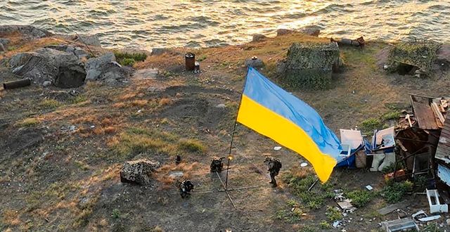 Ormön, 7 juli. Ukrainska soldater hissar den egna flaggan. AP
