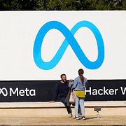 Människor framför Metas logga vid huvudkontoret på  1 Hacker Way i Menlo Park i Kalifornien.