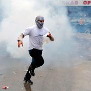 En demonstrant i Beirut kastar tillbaka en tårgasdosa mot polisen. 