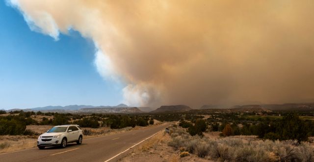 En bil kör iväg från ett rökmoln i bergen i New Mexico, 29 april. Robert Browman / AP