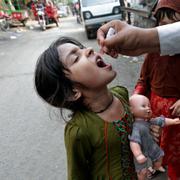 Flicka i Pakistan får vaccin mot Polio. 
