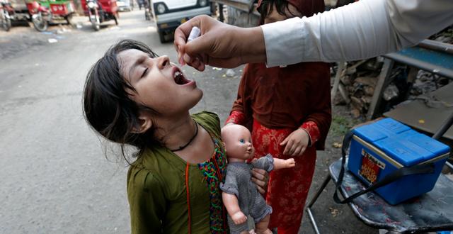 Flicka i Pakistan får vaccin mot Polio.  K.M. Chaudary / AP