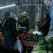 Människor på en grönsaksmarknad i staden Bandar. 