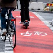 Cyklister och elsparkcykel på cykelöverfart, övergångsställe för cyklar.