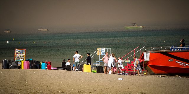 Turister på stranden efter att ha evakuerats. Argyris Mantikos / AP