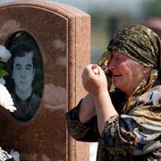 En kvinna sörjer vid graven för Batraz Tuganov, som dog i gisslandramat i Beslan 2004. 