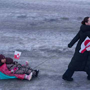 En kvinna drar sitt barn i en pulka under en protest mot USA:s planer på att ta över ön i lördags. 