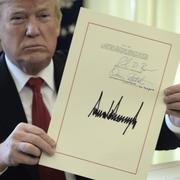 Donald Trump med signaturen för lagen om nya skattepaketet.