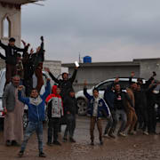 Människor i staden Raqqa firar att den syriska regeringen tagit kontroll över staden. 