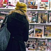  Kvinna tittar på tidningar i en butik. Arkivbild.