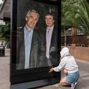 Aktivister sätter upp en affisch som föreställer Donald Trump tillsammans med Jeffrey Epstein vid den amerikanska ambassaden i London.