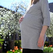 Gravid kvinna utomhus. Genrebild.