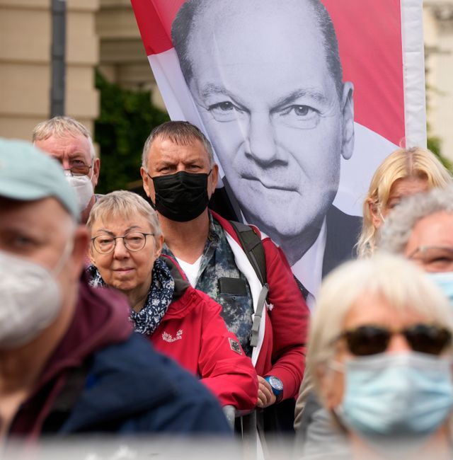 People stand next to a banner of Germany's Social Democratic Party candidate for chancellor in the upcoming national elections, Olaf Scholz, during an election campaign event in Berlin, Germany, Friday, Aug. 27, 2021. Markus Schreiber / TT NYHETSBYRÅN