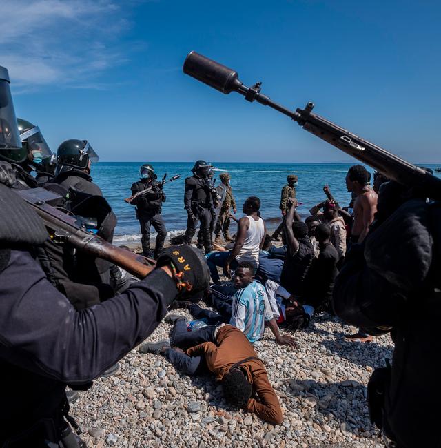 Migrants are surrounded by Spanish police near the border of Morocco and Spain, at the Spanish enclave of Ceuta, on Tuesday, May 18, 2021. Bernat Armangue / TT NYHETSBYRÅN