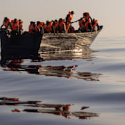 Båt med migranter som fått flytvästar av en räddningsorganisation utanför Lampedusa.  Jeremias Gonzalez / AP